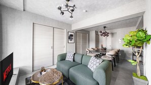 Ein modernes Wohnzimmer mit einer Eckcouch, einem runden Couchtisch und einem Fernseher.