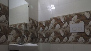 A bathroom with a sink, mirror, and toilet. - Hotel Tavooza Formely Sumangal (Gwalior)