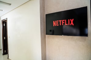 Ein Flur mit einem an der Wand befestigten Schild, auf dem ‘NETFLIX’ steht.
