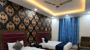 Habitación de hotel con dos camas, ventilador de techo y diseño moderno.