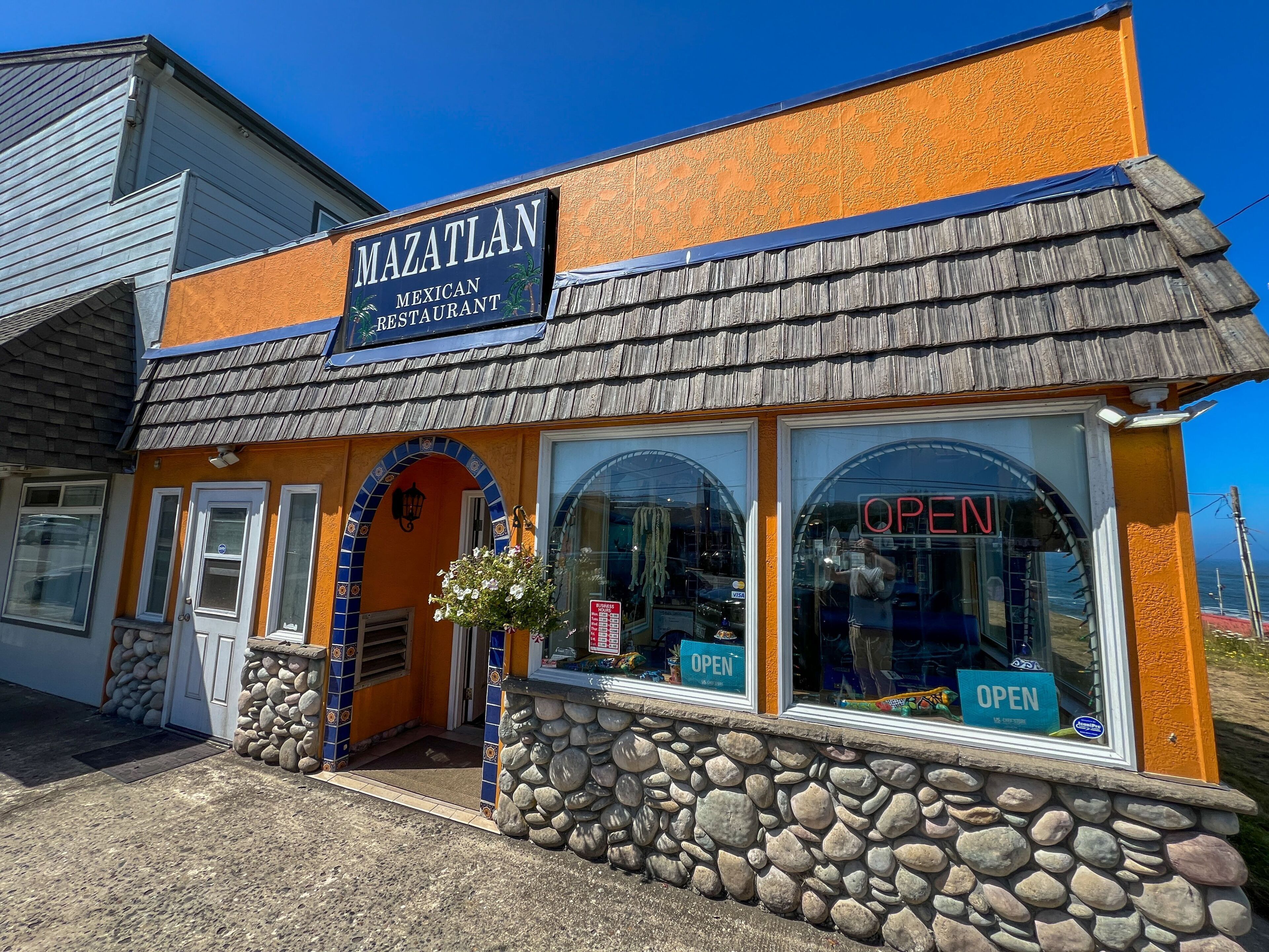 A building with a sign reading "MAZATLAN Mexican Restaurant" and a stone facade.
