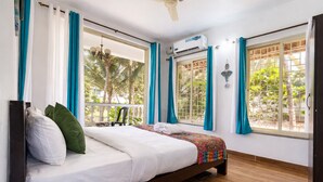 A bedroom with a bed, a ceiling fan, an air conditioning unit, and windows with curtains.