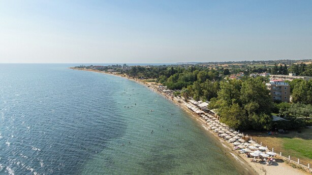 A coastal view with a beach, umbrellas, and buildings. - KYMA STAY - Beachfront apartments  (Thermaikos)