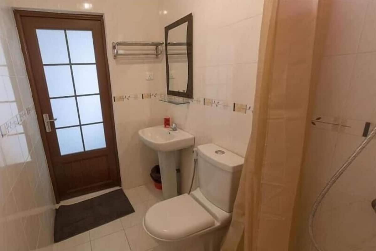 A bathroom with a toilet, sink, and shower.