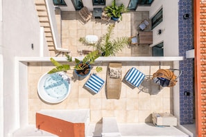 Eine Dachterrasse mit Whirlpool, Liegestühlen, Topfpflanzen und einem Billardtisch.