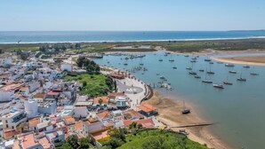 Una località costiera con un porto turistico, edifici e una spiaggia.