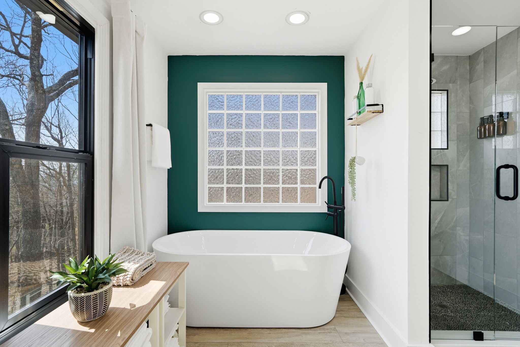 Une salle de bain moderne avec une baignoire sur pieds, une fenêtre en verre dépoli et un espace douche.