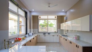 Een moderne keuken met een wit aanrecht, beige kastjes en een raam dat natuurlijk licht binnenlaat.