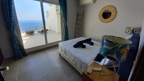 Ein Schlafzimmer mit Bett, Nachttisch, Lampe, einem Fenster mit Vorhängen, einer Leitern und einer Klimaanlage.