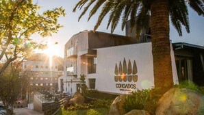 A hotel named 'COROADOS' with a modern architectural style, featuring a prominent signboard, a staircase leading to the entrance, and surrounding greenery. - COROADOS HOTEL E FLATS LTDA (Nova Prata)