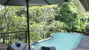 A poolside area with lounge chairs and a canopy. - Babakan Hill Villas (Karangasem)
