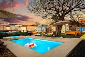 A swimming pool with lounge chairs, umbrellas, and a tree. - Heated Pool/Court/Casita/Game Room/Movie Drive-in (San Antonio)