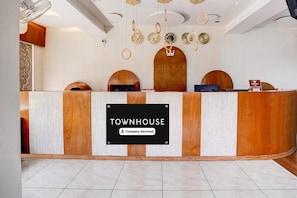 A reception desk with a sign reading 'TOWNHOUSE Company-Serviced.'