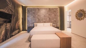 A modern bedroom with a large bed, a bench, and a decorative wall. - The luxury villa Ivory E3 Rawai Phuket (Rawai)