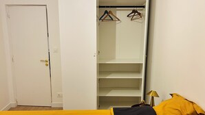 A bedroom with a bed, a wardrobe, and a nightstand. - Luxury apartment with parking, river and forest views, 5 min. from the center! (La Châtre)