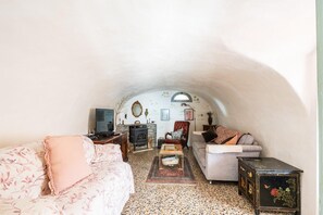 An arched living room with a fireplace, a sofa, a coffee table, and a side table.