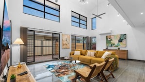A spacious living area with a sofa, chairs, a coffee table, and artwork on the walls. - Zen Tropica Family Luxury Retreat Pool BBQ (Darwin)