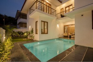 A modern two-story house with a swimming pool, a balcony, and a well-lit interior. - Casa Toledo 4BR in Candolim w Pvt Pool Near Beach (Candolim)