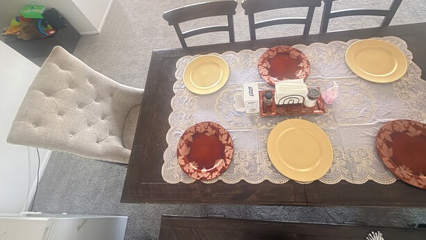 Una mesa con platos, una jarrón y una bandeja.