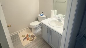Un baño con inodoro, lavamanos y espejo.