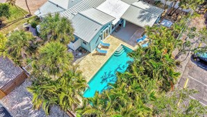 Ein Haus mit Swimmingpool, umgeben von Palmen.