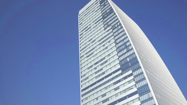 A tall, modern skyscraper with a curved design and numerous windows. - Hotel Livemax Budget Nagoya Taiko Doriguchi (Nagoya)
