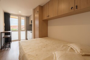 A bedroom with a bed, a desk, and a wardrobe. - Eco-Bungalow Vista Serra da Estrela (Seia)