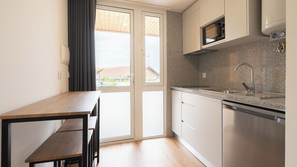 Una cocina con encimera, lavabo y lavavajillas.
