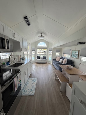 Une cuisine spacieuse dotée d’un îlot central, un coin repas avec une banquette et un espace salon confortable avec un canapé.