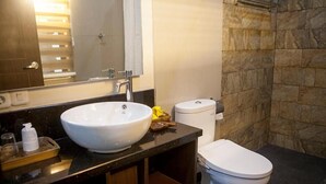 A bathroom with a white sink, a toilet, and a shower area. - Villa Sawah Hotel and Resort (Megamendung)