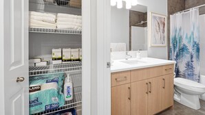 A bathroom with a shower curtain, a sink, and a toilet. - Luxury 2bedroom Suite With Park Views in Calgary (Calgary)