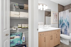 A bathroom with a shower curtain, a sink, and a toilet. - Luxury 2bedroom Suite With Park Views in Calgary (Calgary)