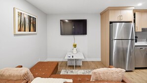 A modern living room with a sofa, a coffee table, and a flat-screen TV mounted on the wall. - Luxury 2bedroom Suite With Park Views in Calgary (Calgary)
