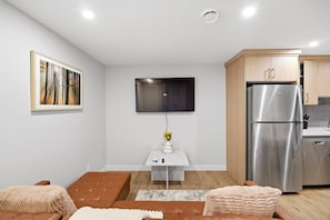 A modern living room with a sofa, a coffee table, and a flat-screen TV mounted on the wall. - Luxury 2bedroom Suite With Park Views in Calgary (Calgary)