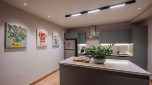 A modern kitchen with a central island, recessed lighting, and wall-mounted artwork. - Casa del Orfebre Colonial Home in Zona Colonial , Pool & Private Patio (Santo Domingo)