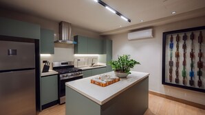A modern kitchen with a central island, stainless steel appliances, and a potted plant. - Casa del Orfebre Colonial Home in Zona Colonial , Pool & Private Patio (Santo Domingo)