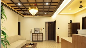 A modern living room with a sofa, coffee table, and a decorative cabinet. - Hotel Liora (Rajkot)