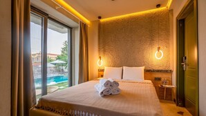 Una habitación de hotel con cama, baño y vistas a una piscina.