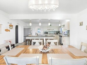 A modern kitchen with a central island, white cabinetry, and pendant lighting. - Villa Esperanza Ocean View Villa |Private Pool | Gated Community | Walk to Beach (Dawn Beach)