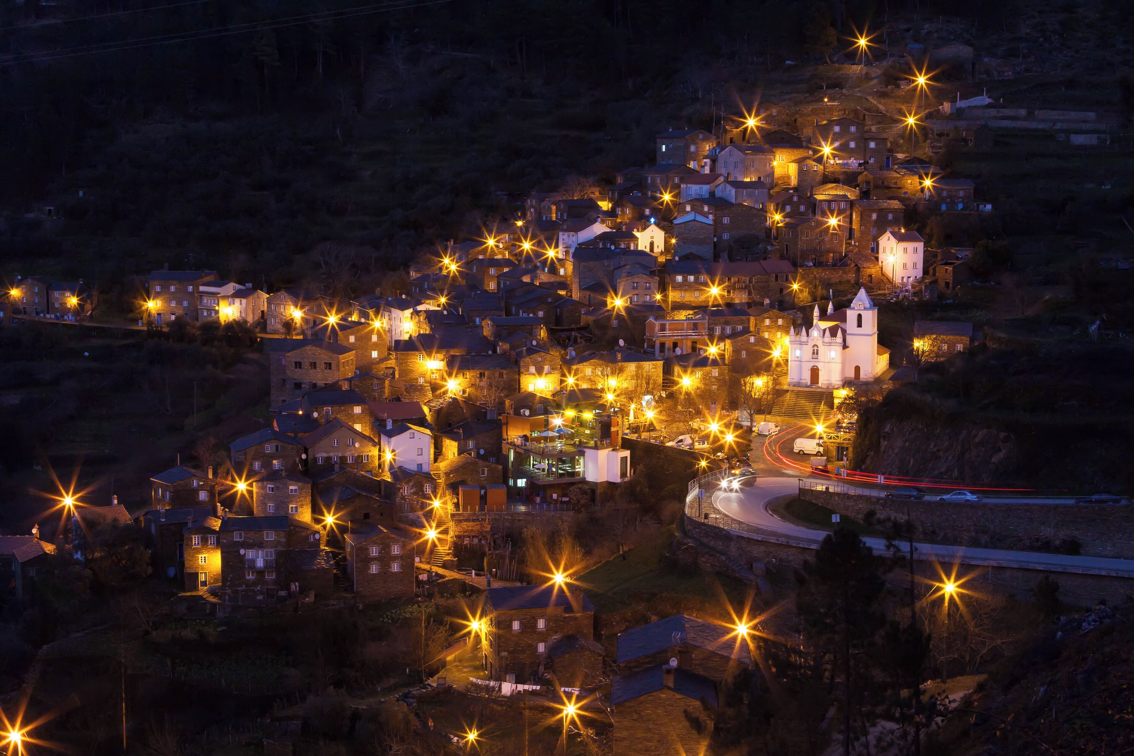 A town at night with illuminated buildings and a church.