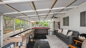 A modern indoor pool area with a pool table, a sofa, and a ceiling fan. - Resort-Style Pool Retreat | Home Gym + Hot Tub (Goleta)