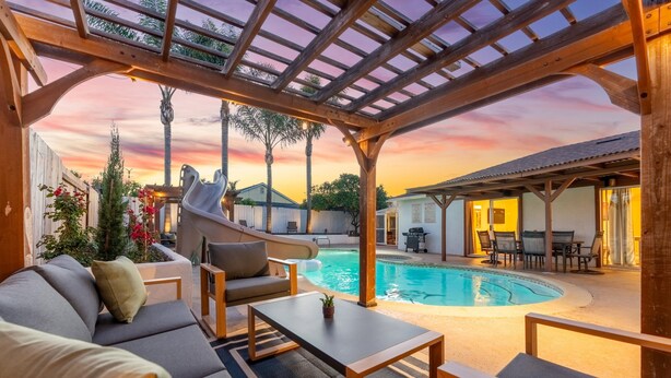 A poolside area with a covered seating area, a slide, and a pool. - Resort-Style Pool Retreat | Home Gym + Hot Tub (Goleta)