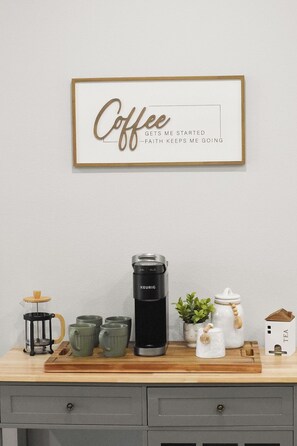 A coffee-themed decor with a framed quote, a Keurig coffee maker, mugs, a sugar jar, and a tea box on a wooden tray. - Superb 2-bedroom house with AC in sunny Sarasota (Sarasota)