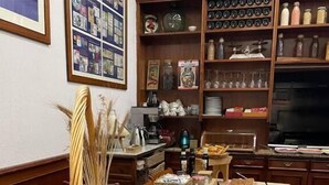 Une cuisine avec une table en bois, deux grille-pain, un panier de pain et divers ustensiles de cuisine.