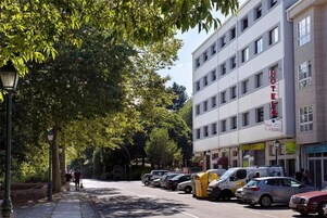 Un hotel con fachada moderna, varios pisos y un letrero que indica que es un hotel.