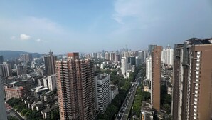 Una zona urbana con rascacielos, una calle concurrida y cielo despejado.
