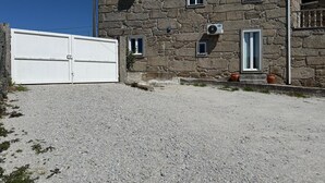 A stone building with a white garage door, multiple windows, and air conditioning units.