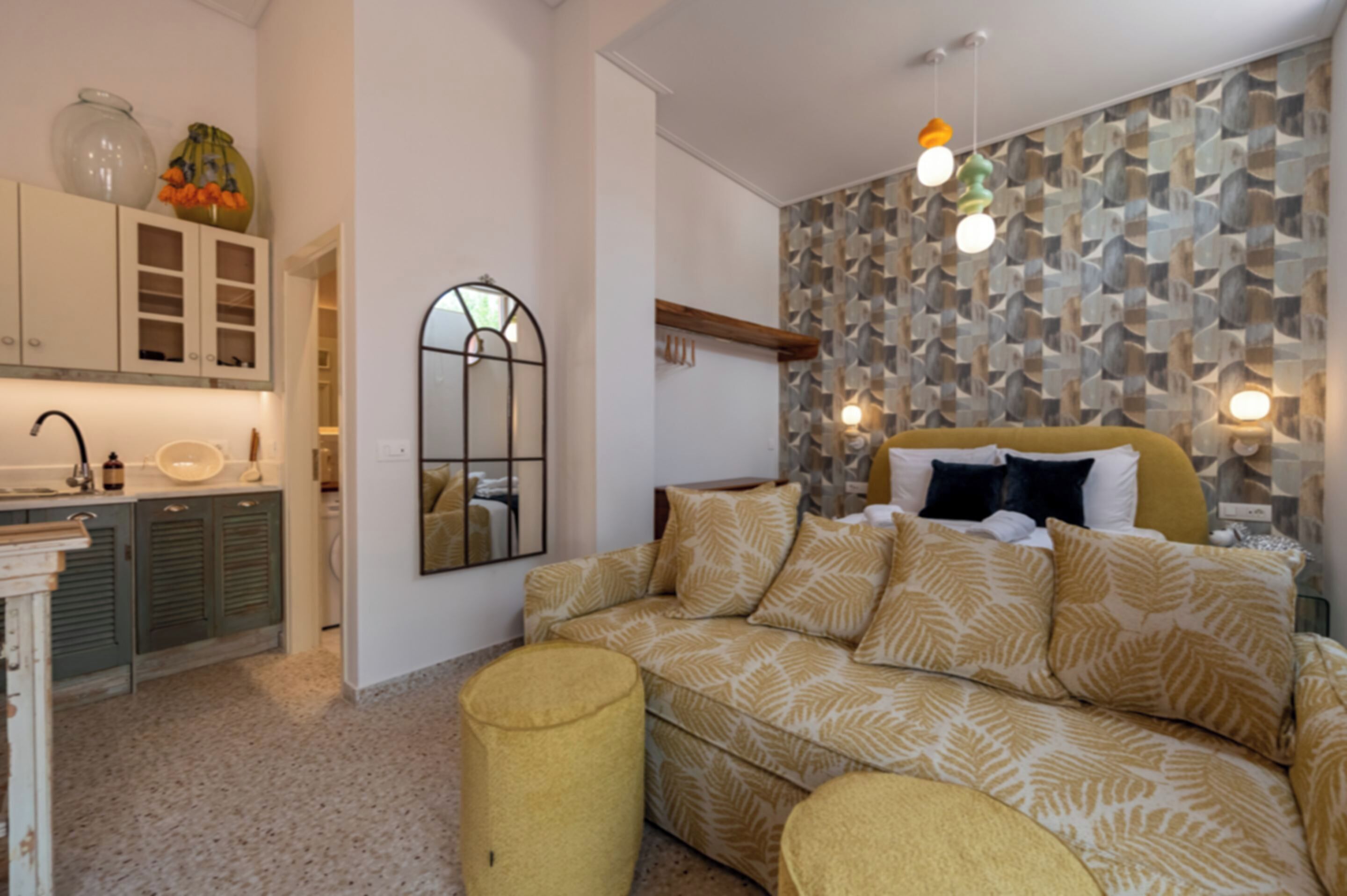 Un intérieur moderne avec un canapé, un miroir et un mur orné d’un motif.