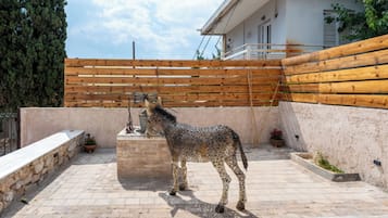 Un patio con una estatua de un caballo, una valla de madera y un edificio con balcón.