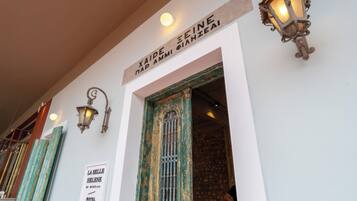 Entrada de hotel con un letrero que dice 'XIAIDE PAI AMI PAIHZEAI' y un letrero que anuncia 'LA BELLE HELENE HOTEL'.